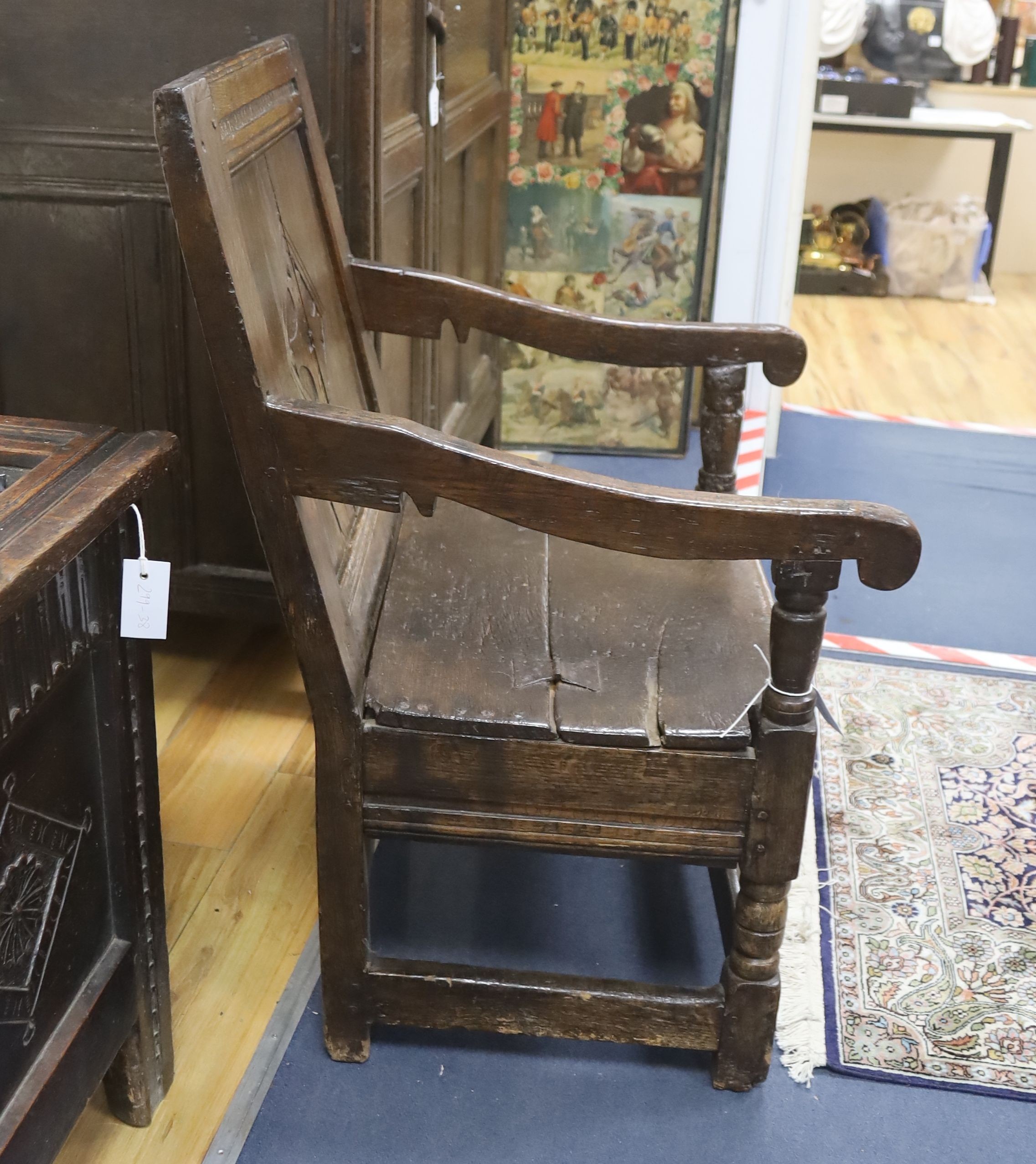 A joined oak merchant’s wainscot box-seated chair, the twin panelled back carved with a stylised cross in diamond device, early-mid 17th century, width 62cm, depth 62cm, height 91cm